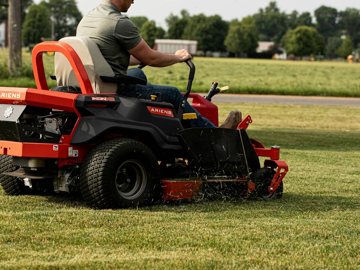 Landscaper cutting grass on a commercial zero-turn mower